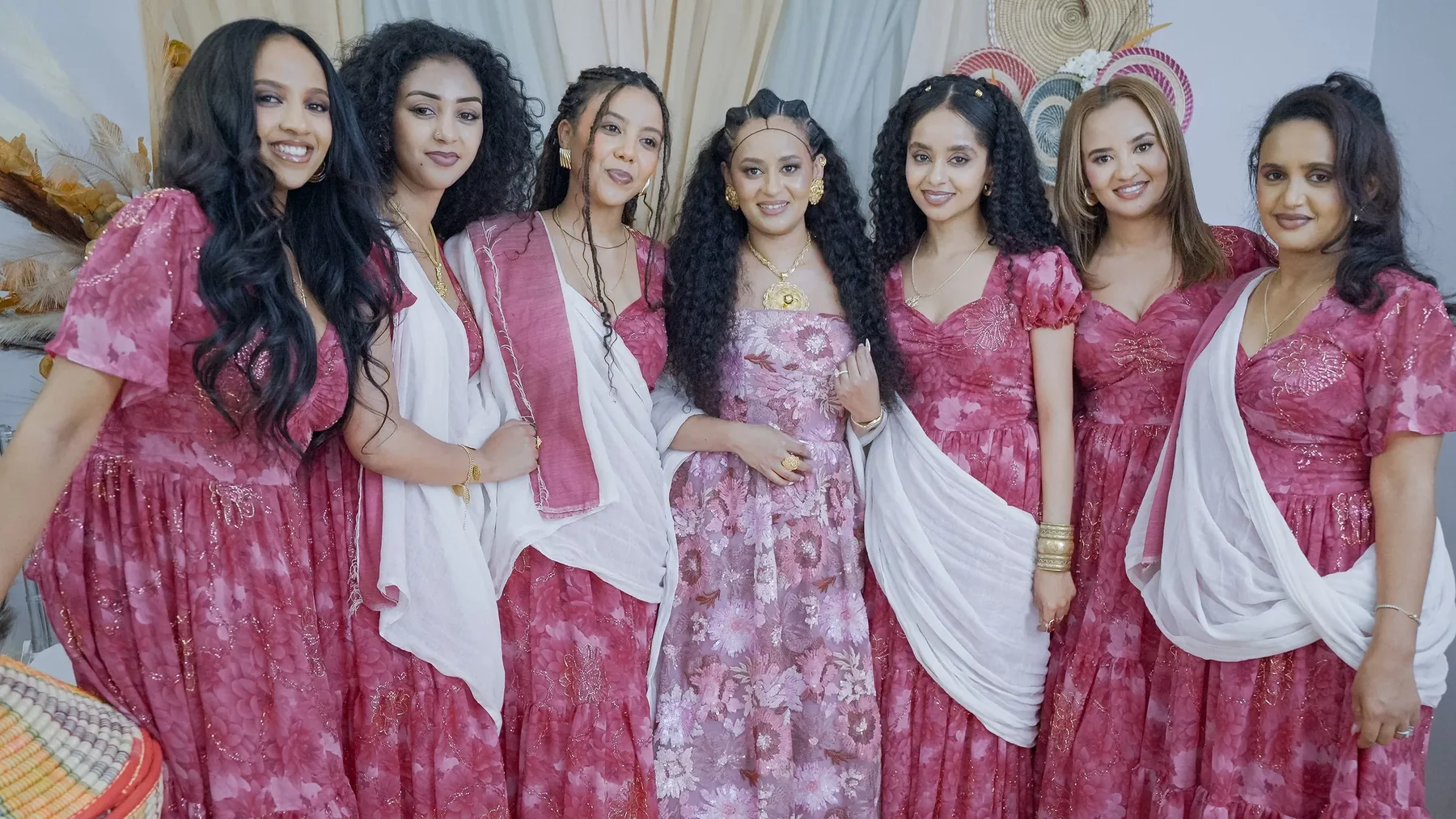 The full group in coordinated traditional dress, the closing frame of the celebration