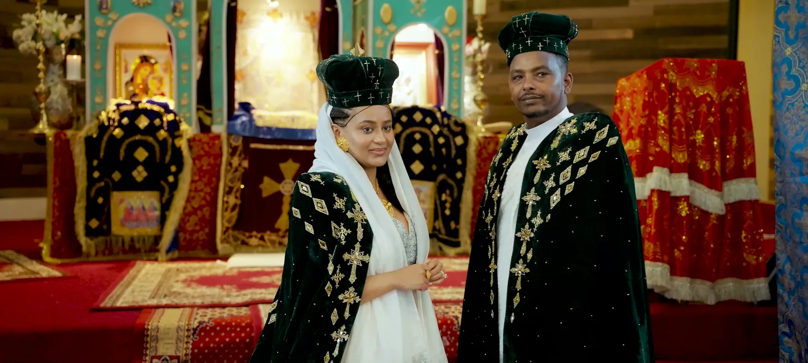 The couple at the altar in ceremonial dress, the congregation behind them